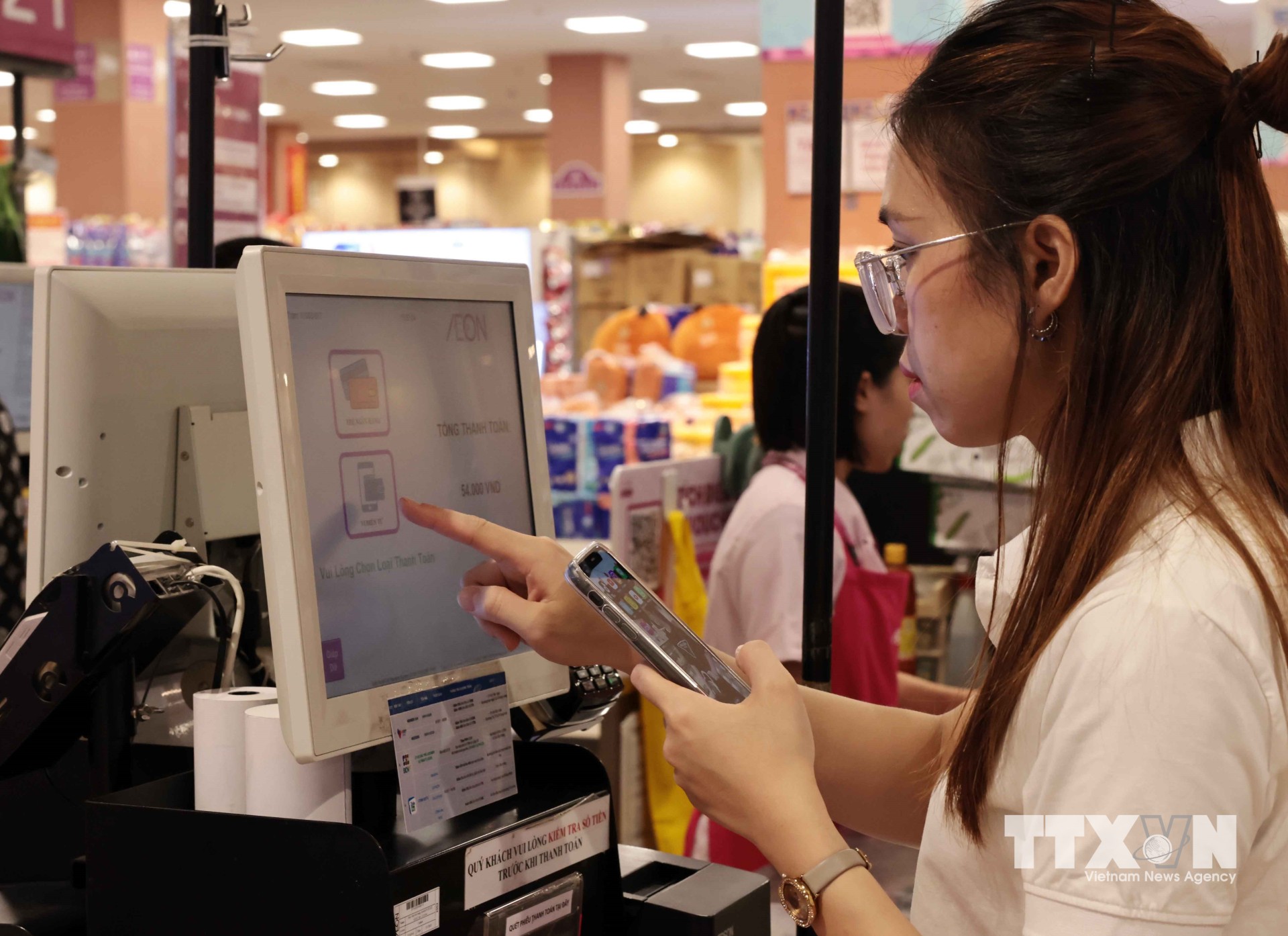 Chỉ với một chiếc smart phone kết nối Internet, khách hàng có thể dễ dàng giao dịch trong khoảng thời gian vài giây với những thao tác đơn giản. (Ảnh: Trần Việt/TTXVN)